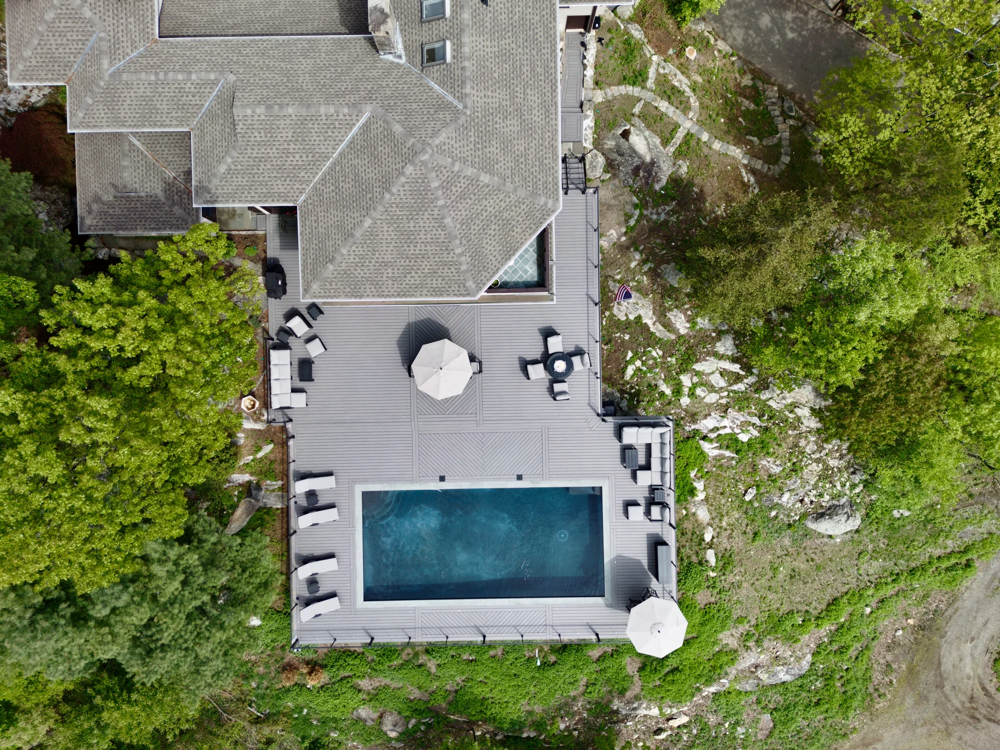 Aerial of a pool deck on a wooded Hudson Valley hillside