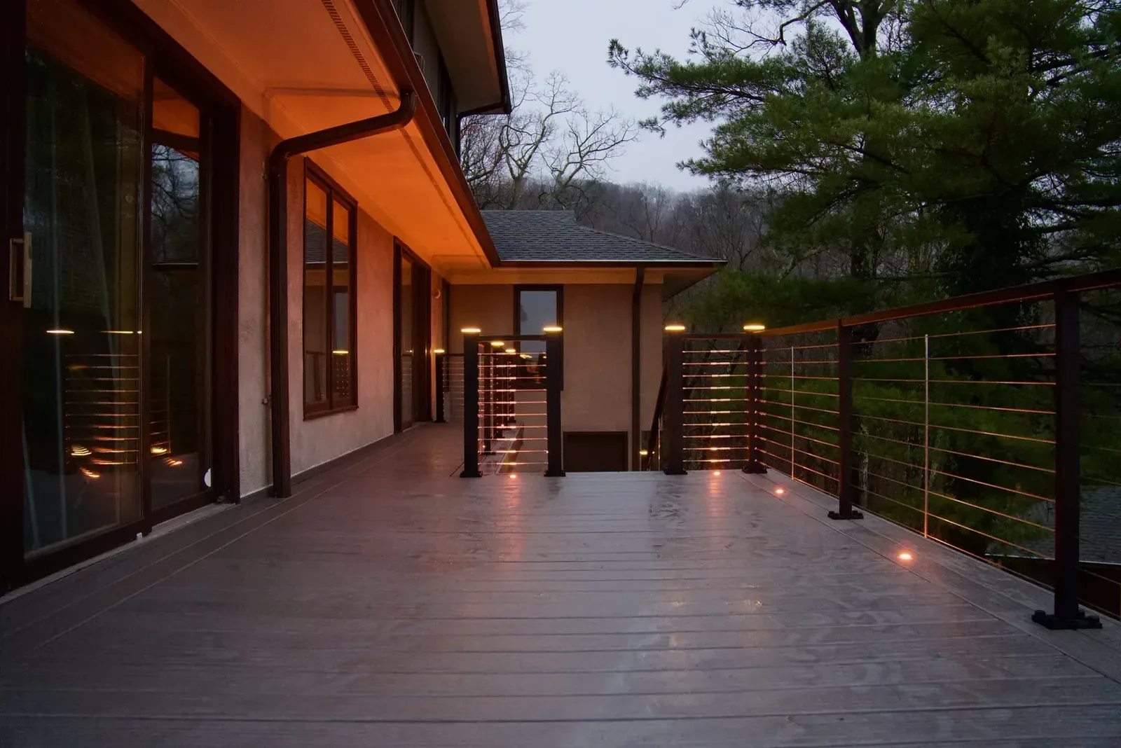 Covered deck breezeway with finished ceiling lit at dusk