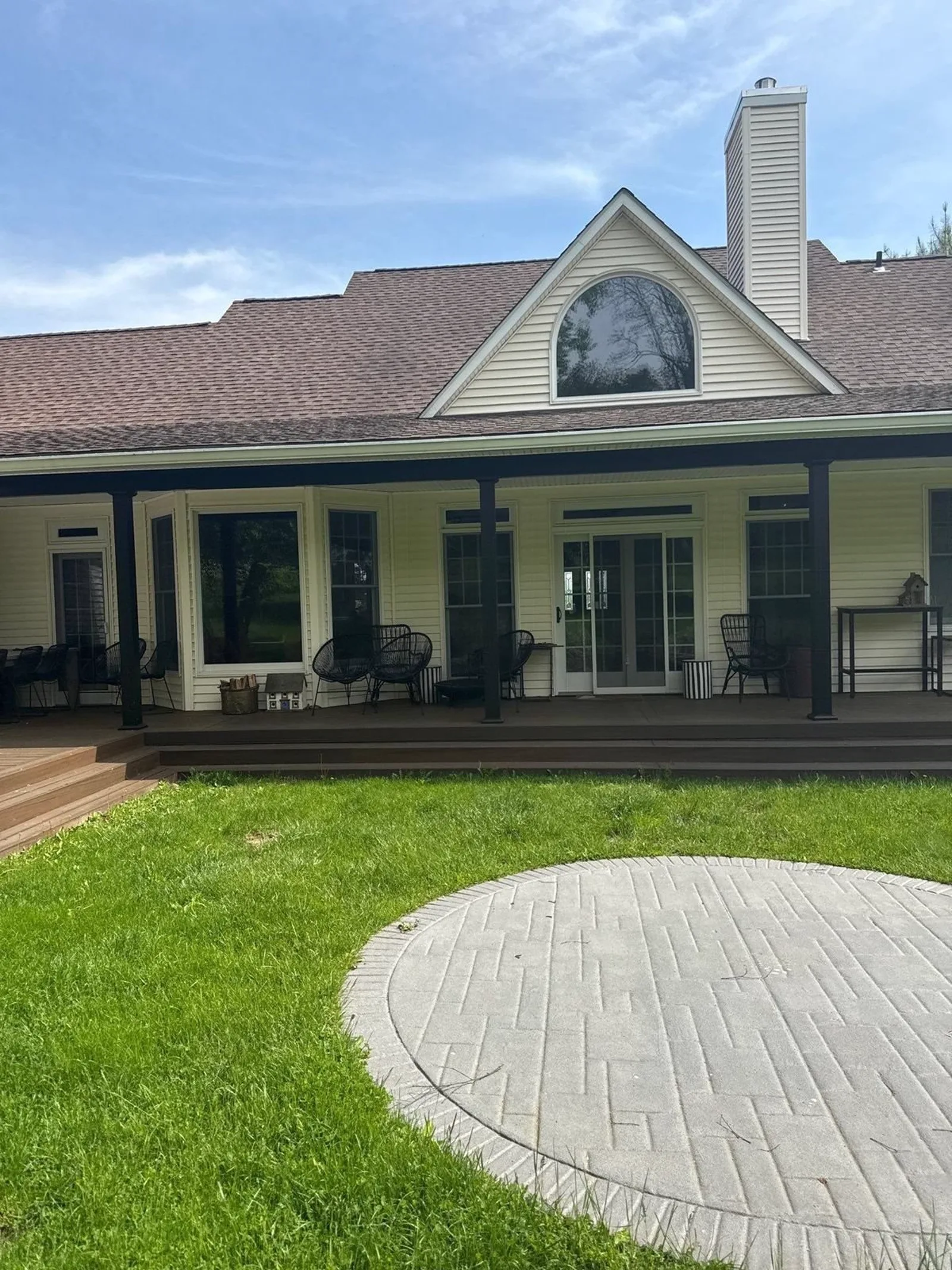 Finished covered porch and stamped paver circle under a clear sky