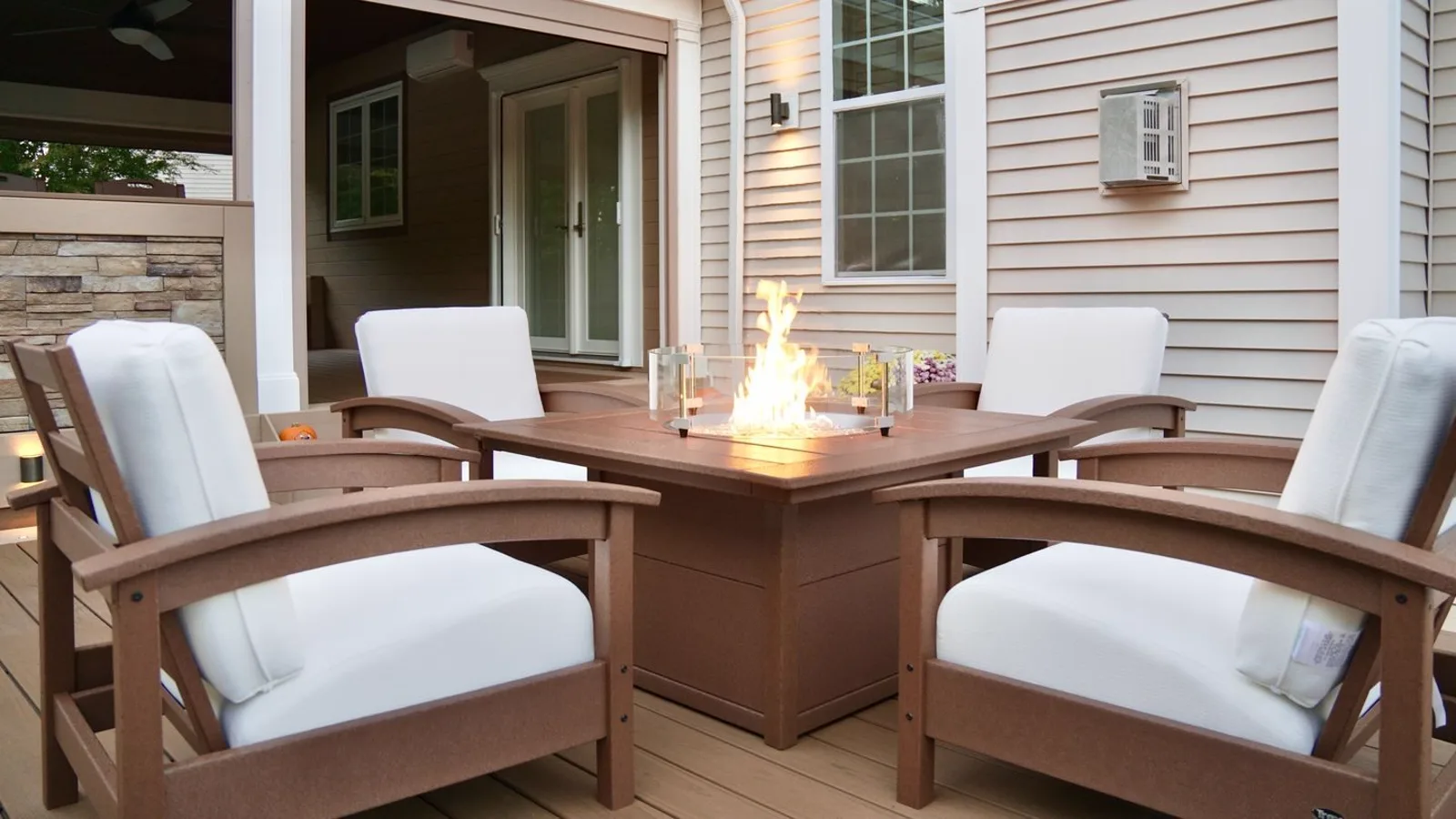 Fire table and lounge seating on a deck after dark