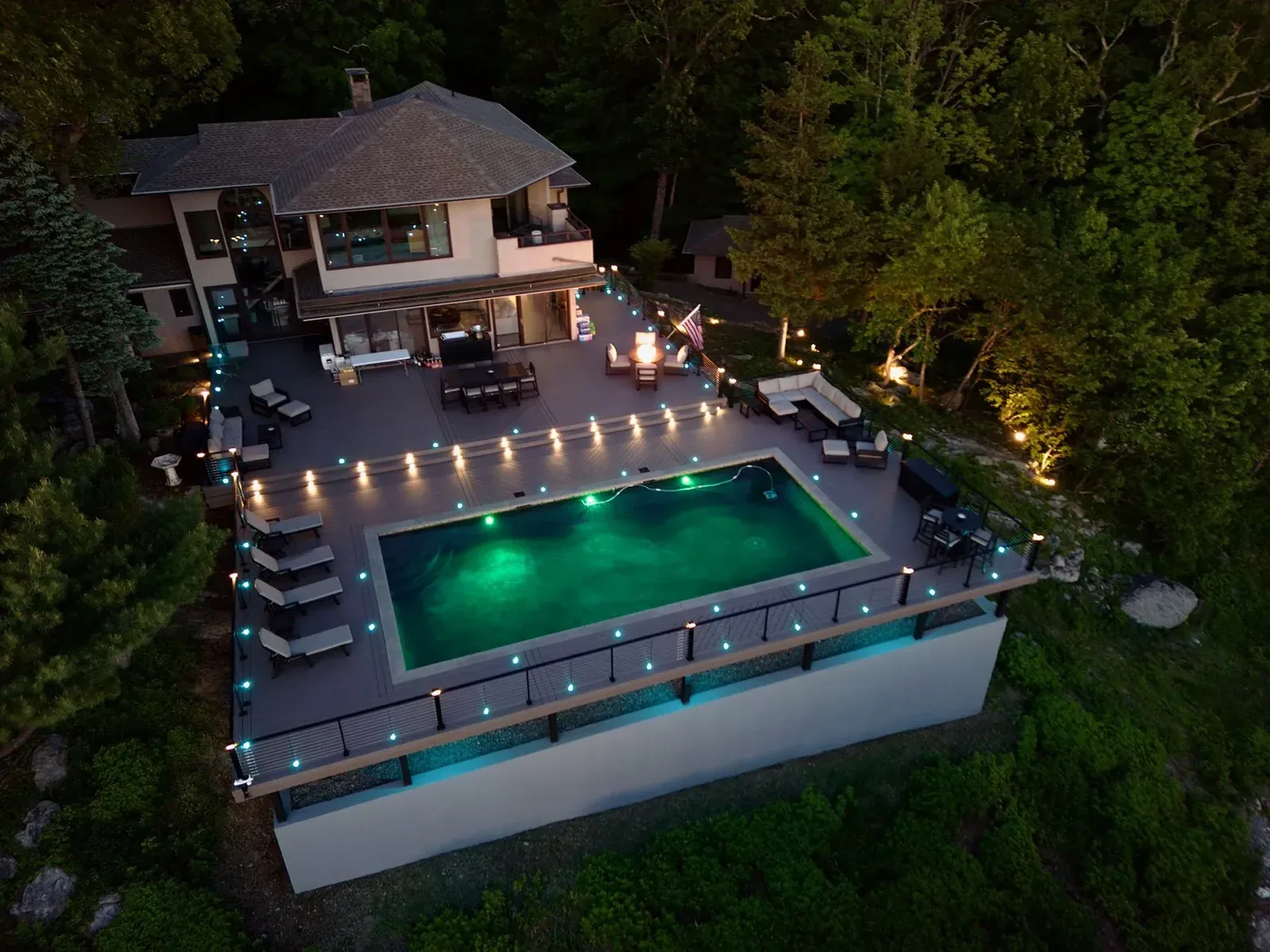 Illuminated pool and deck seen from the air at night