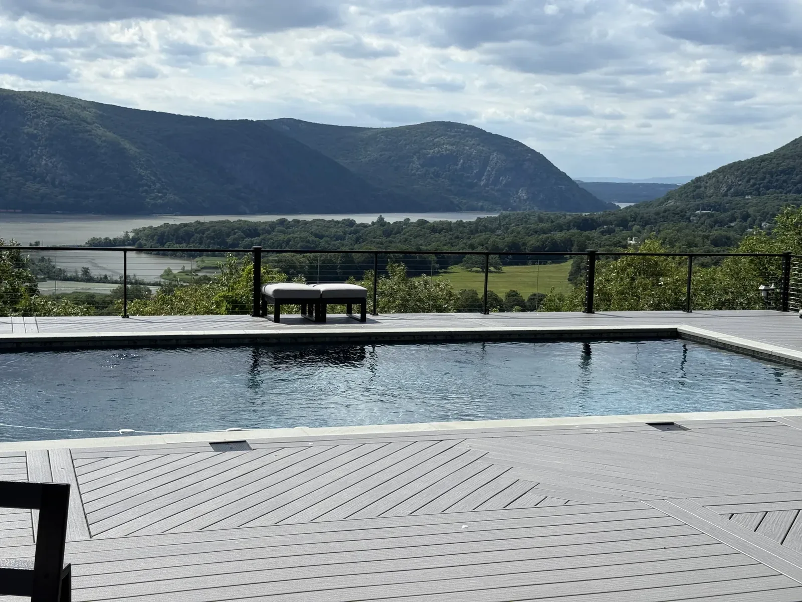 Pool set into the Whidbey deck at Hudson Horizon Haven, with the cable railing keeping the Hudson River and the Highlands unobstructed beyond the water