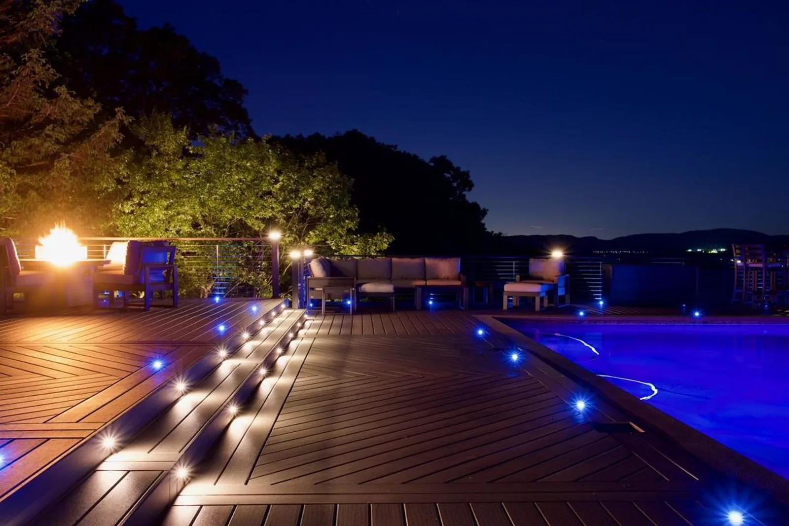 Haven lighting zones running at night on the Hudson Horizon Haven pool deck — lit stair risers, in-deck perimeter fixtures, and the pool glowing as its own zone