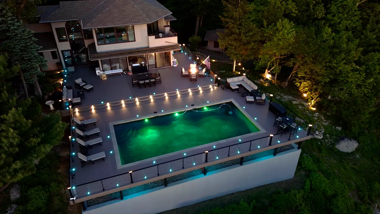 Finished pool deck and outdoor living space lit at night