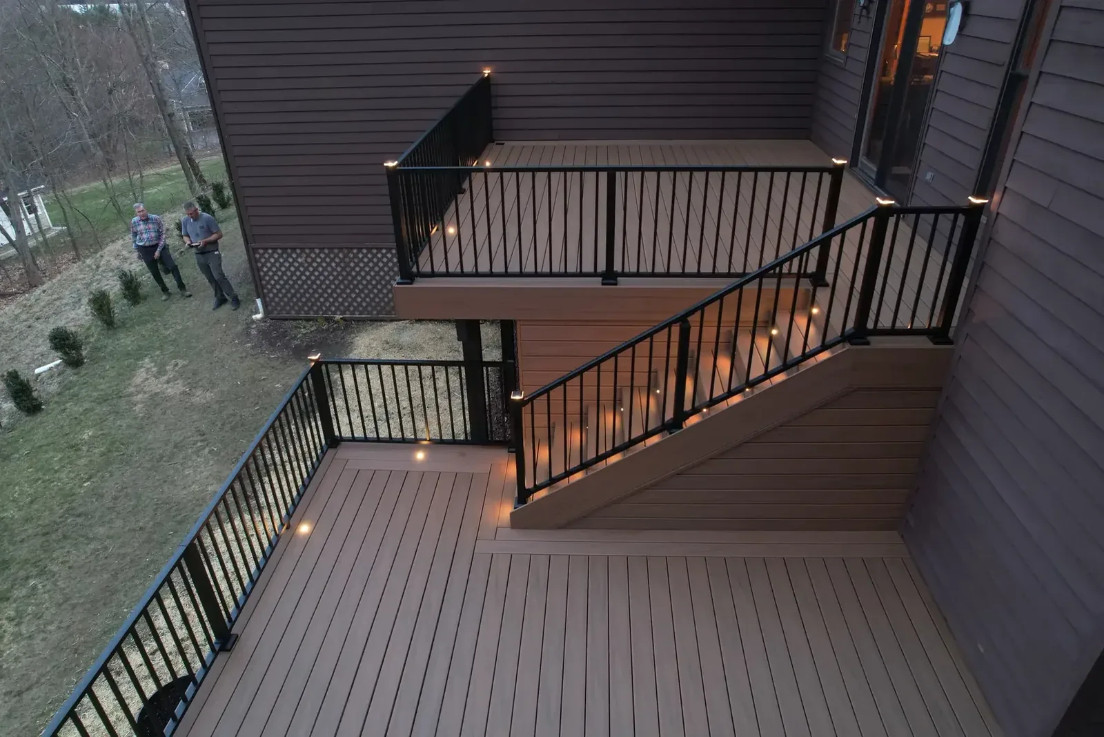 Multi-level composite deck with LED-lit steps at night in the Hudson Valley, NY