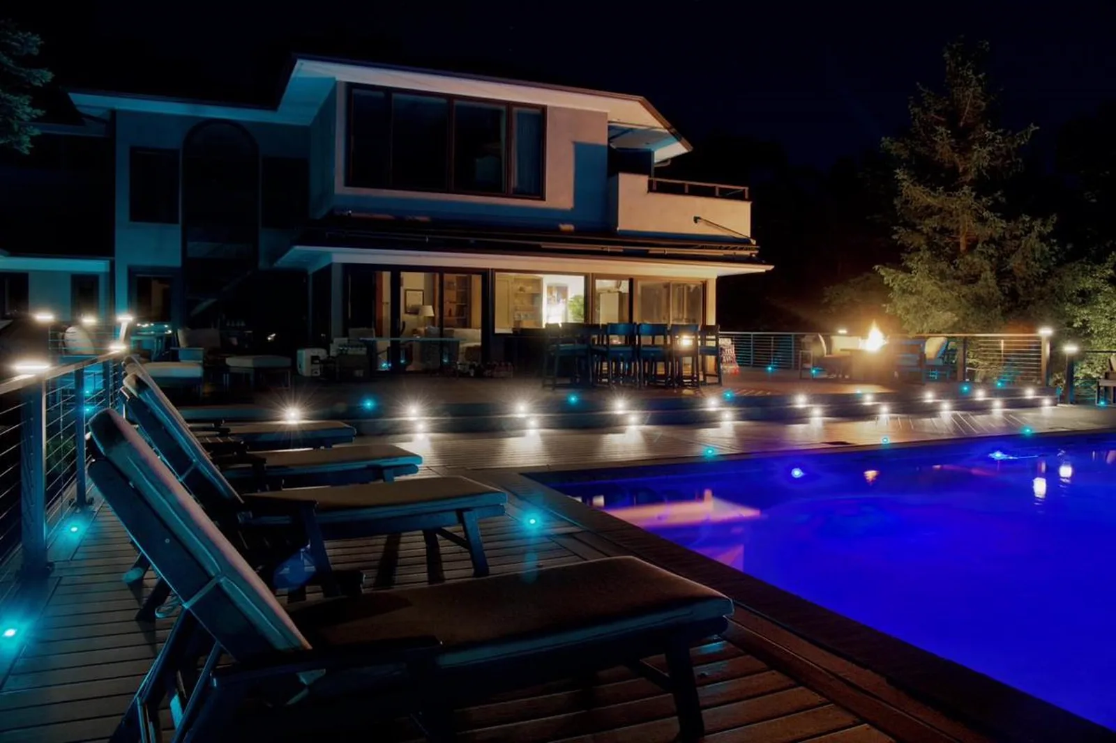 Night pool deck with Trex Signature Aluminum Railing and Haven Full Color LED Deck Light