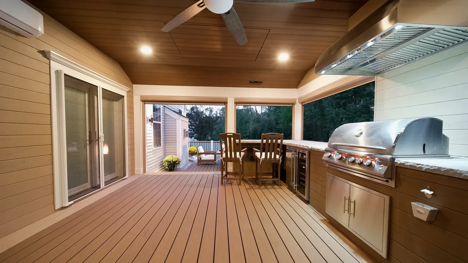 Outdoor kitchen on a composite deck under evening lighting
