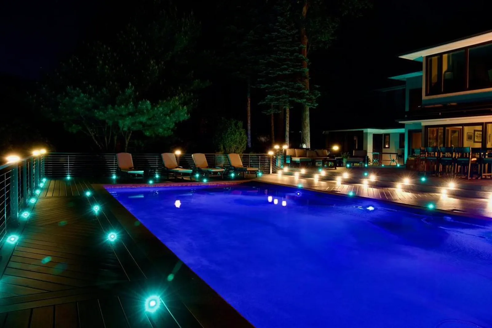 Pool deck with Signature aluminum railing and blue lighting