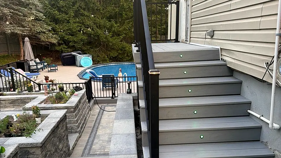 Stair riser lighting and black railing detail that should be specified before a deck proposal is signed
