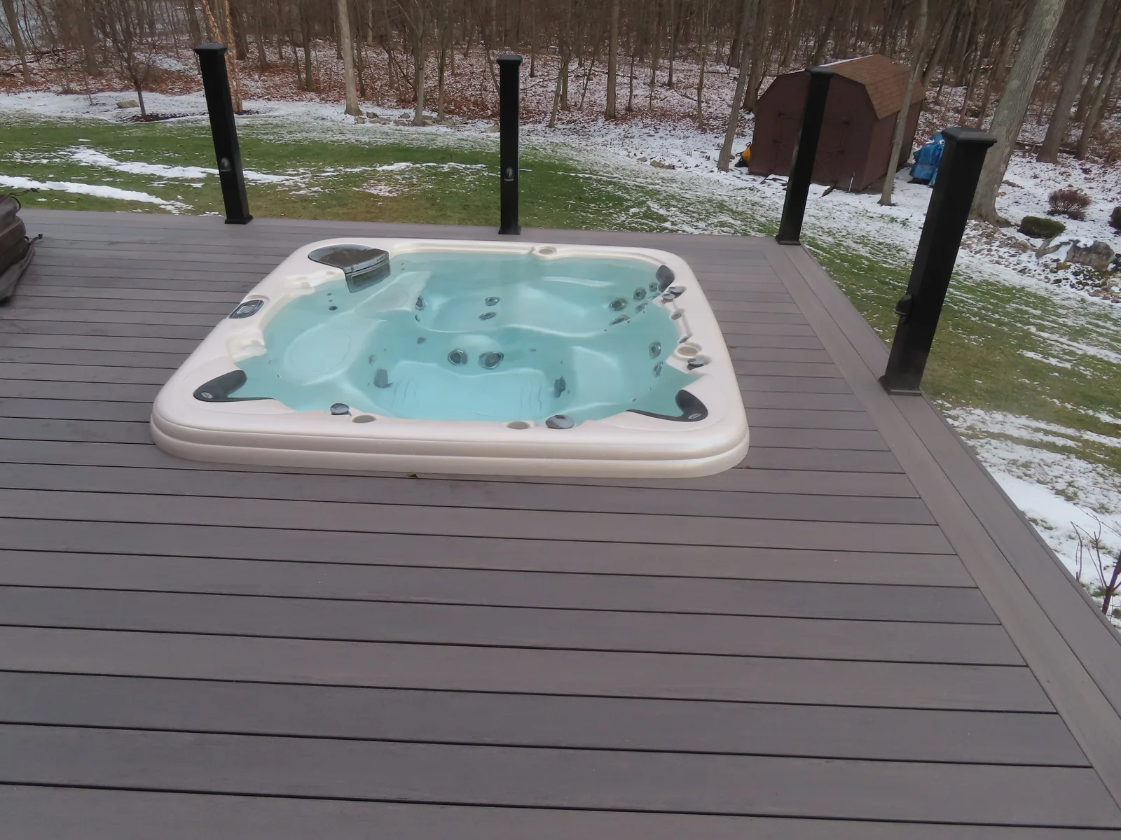 Spa set flush into the composite deck with black railing posts