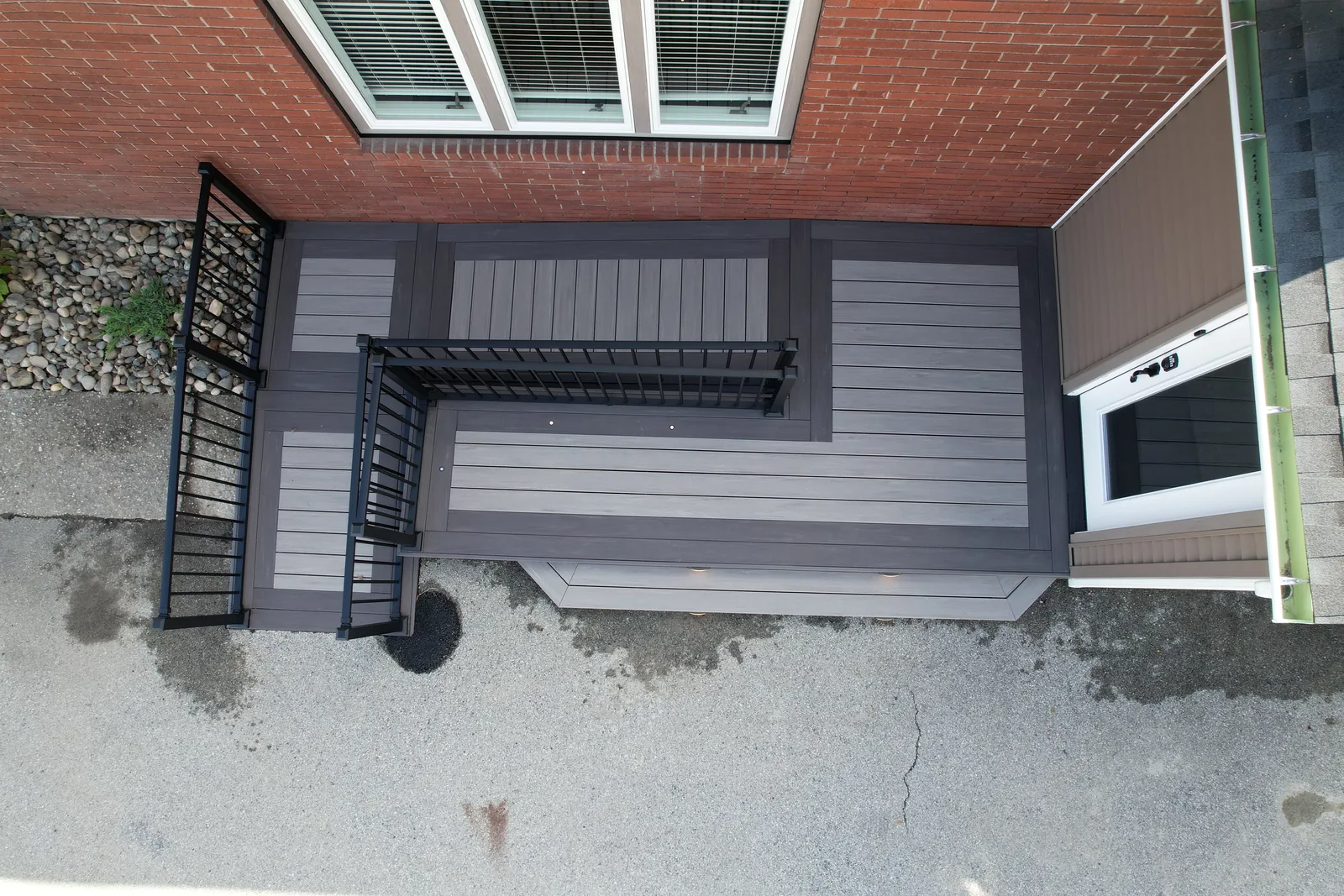 Overhead view of a TimberTech deck showing a banded border and inlay pattern with black railing