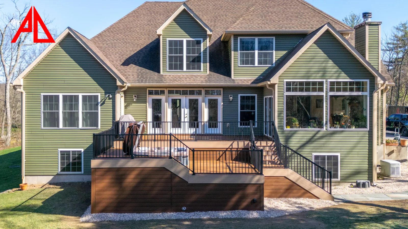 Two-level Trex Select deck across the back of a Hudson Valley home, with stairs, black Trex Signature railing, and skirted structure