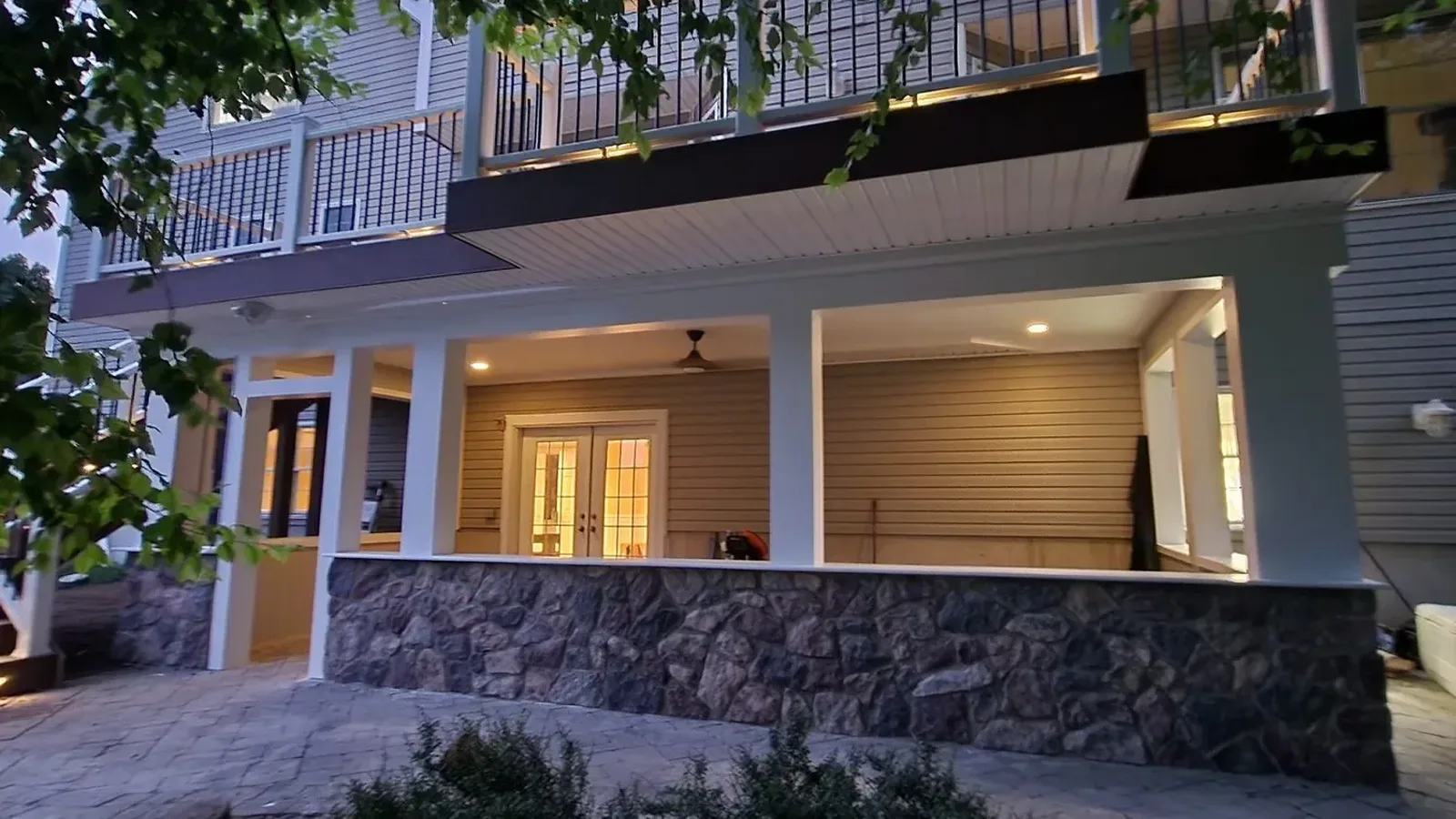 Finished under-deck living space with a stone base and recessed ceiling lighting