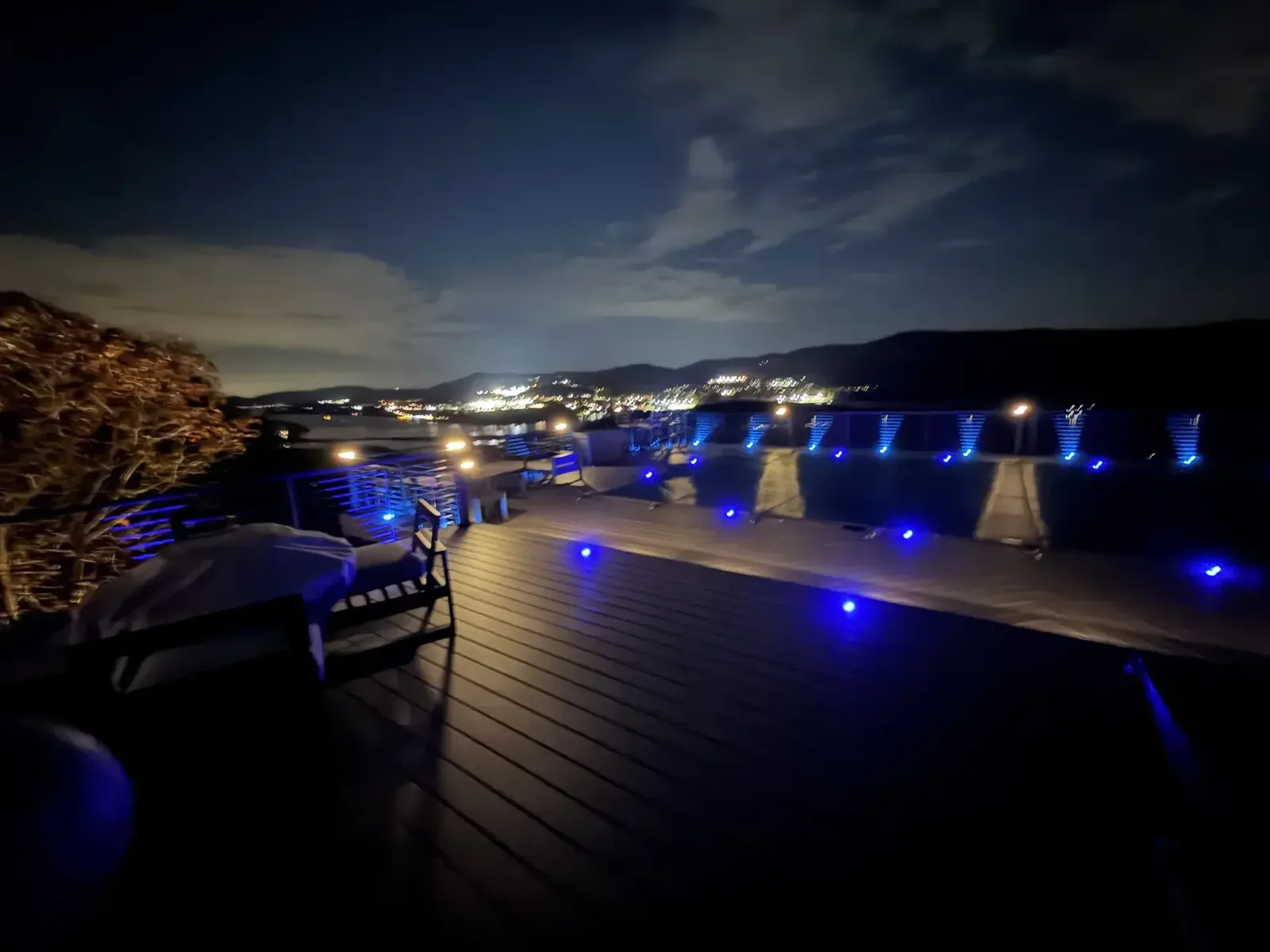 Waterfront deck with blue LED railing lighting at night