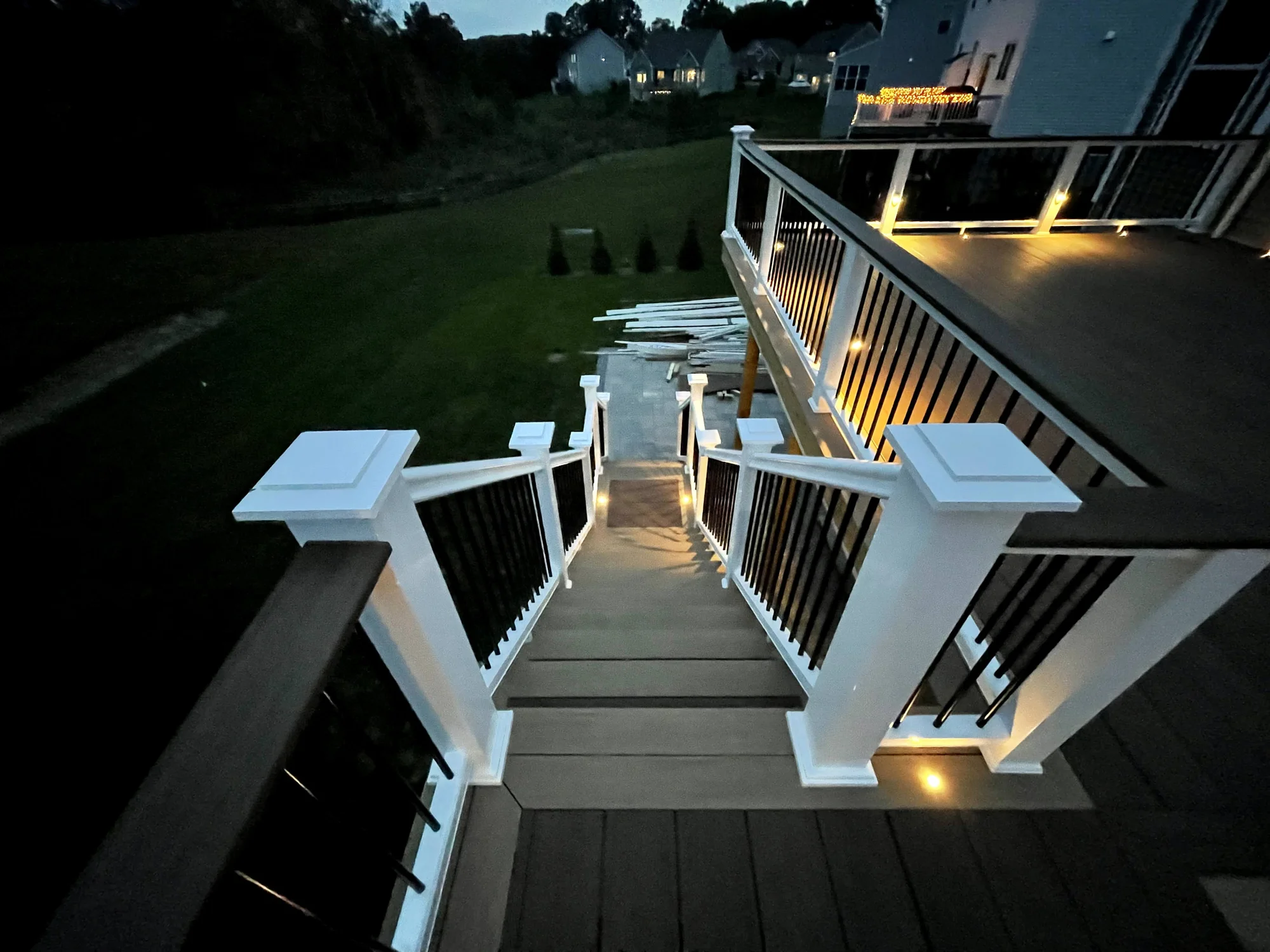 Deck stairs with white railing and Haven LED lighting at dusk in the Hudson Valley