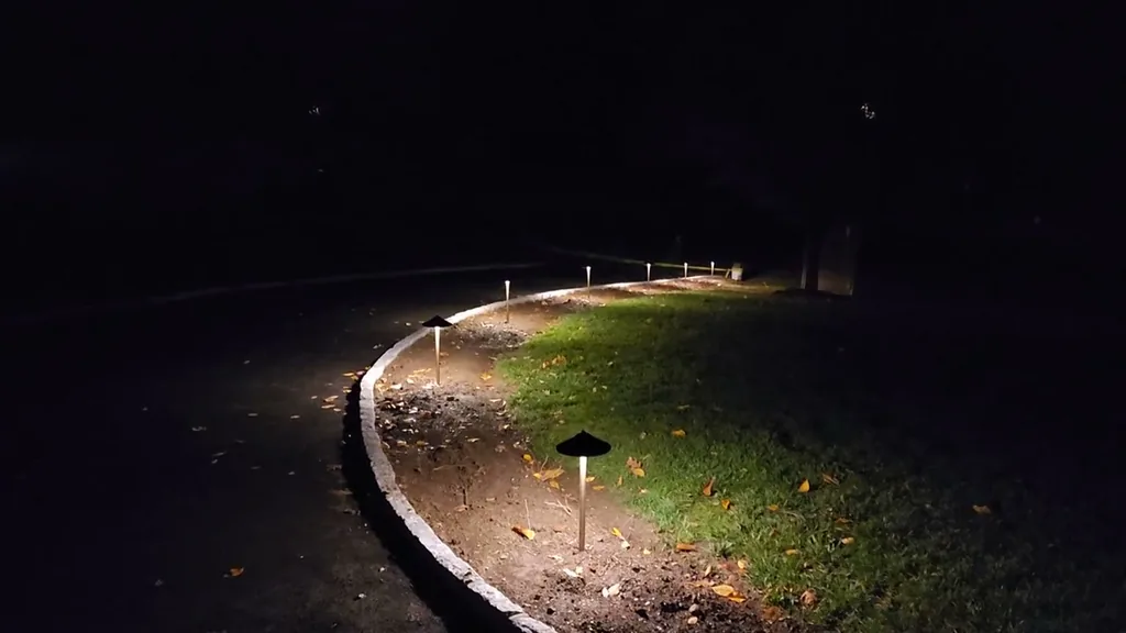 Night landscape path lighting along a paver walkway