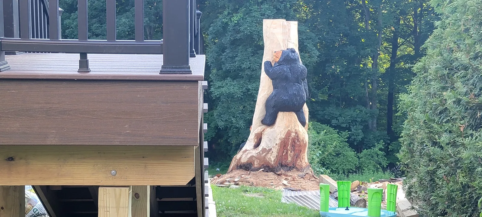 Corner of an elevated deck with dark railing beside a carved bear sculpture, Putnam County