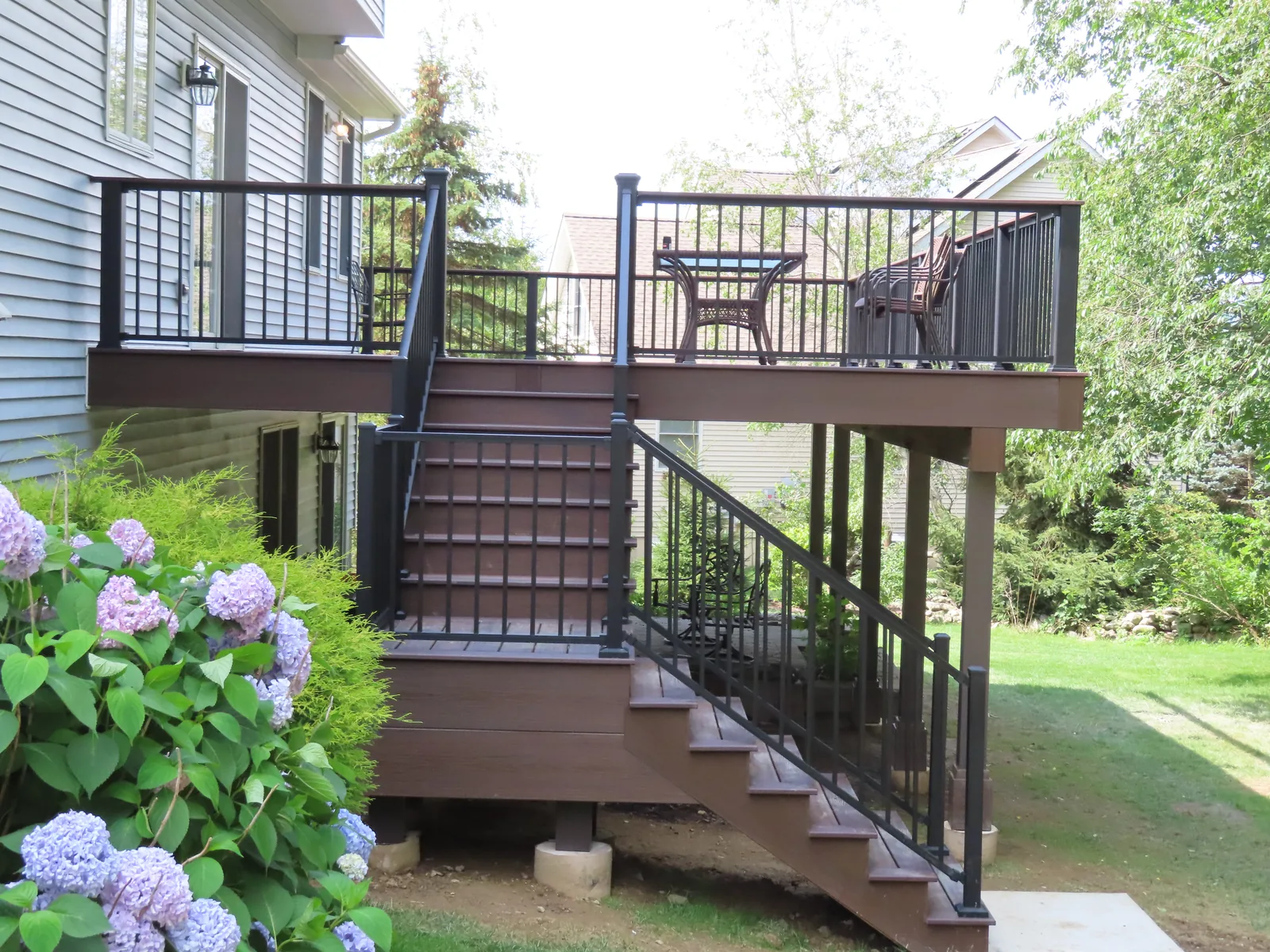 Raised composite deck and stairs framed by blooming hydrangeas in the Hudson Valley, NY