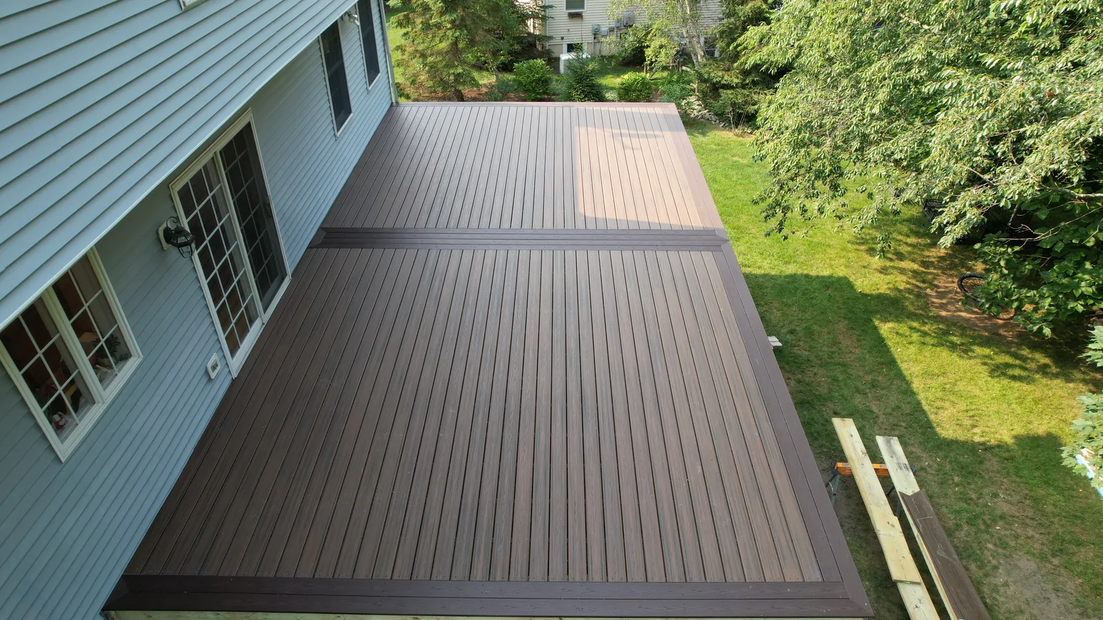 Drone aerial of a finished deck beside mature trees in the Hudson Valley, NY