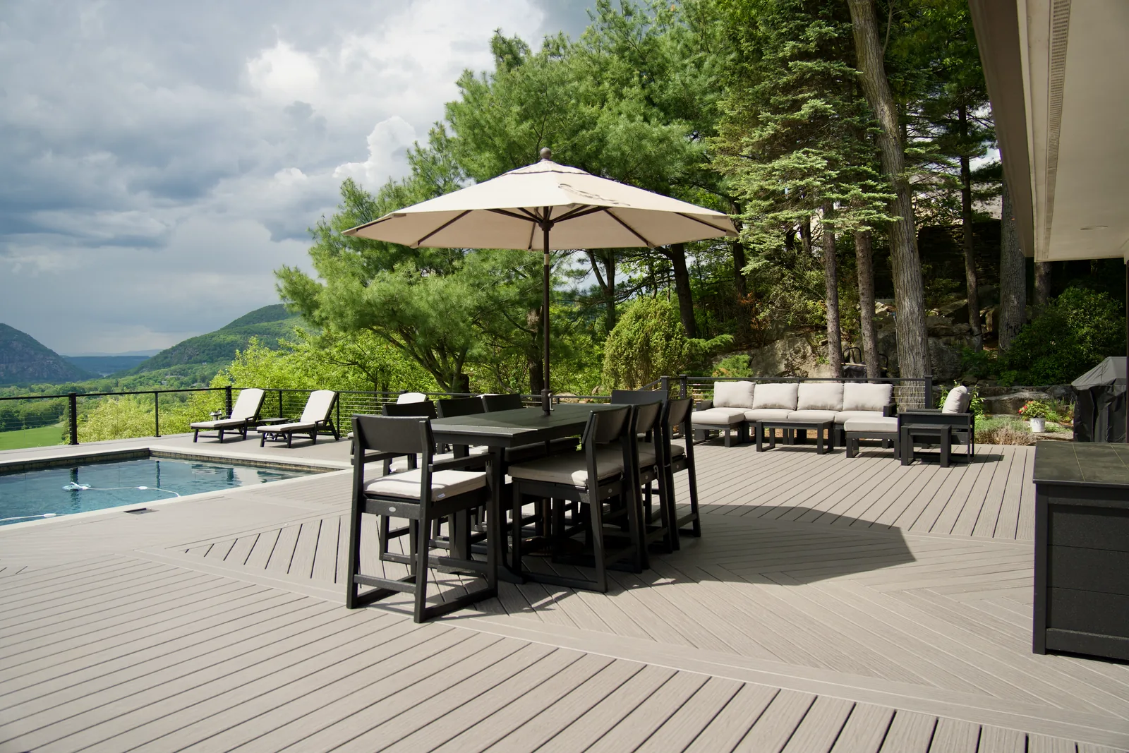 Umbrella dining set poolside with Hudson Highlands view in Garrison, NY