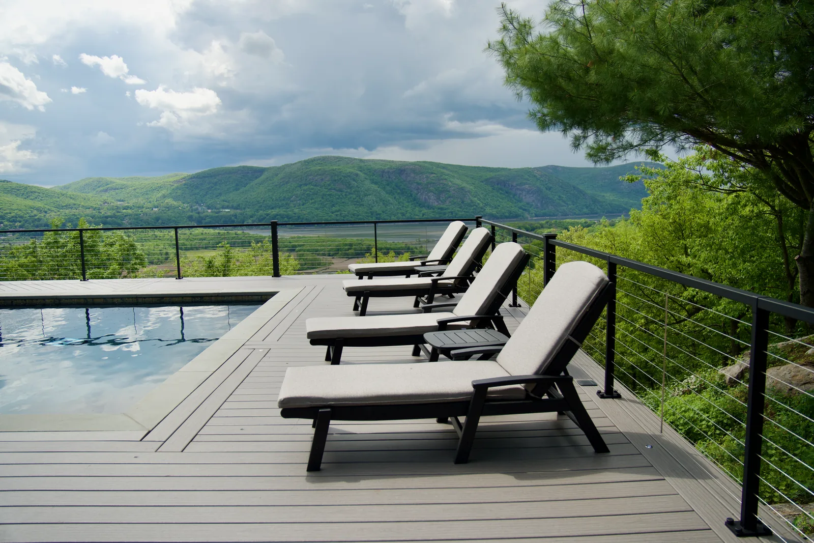 Lounge chairs lining pool with mountain panorama in Garrison, NY
