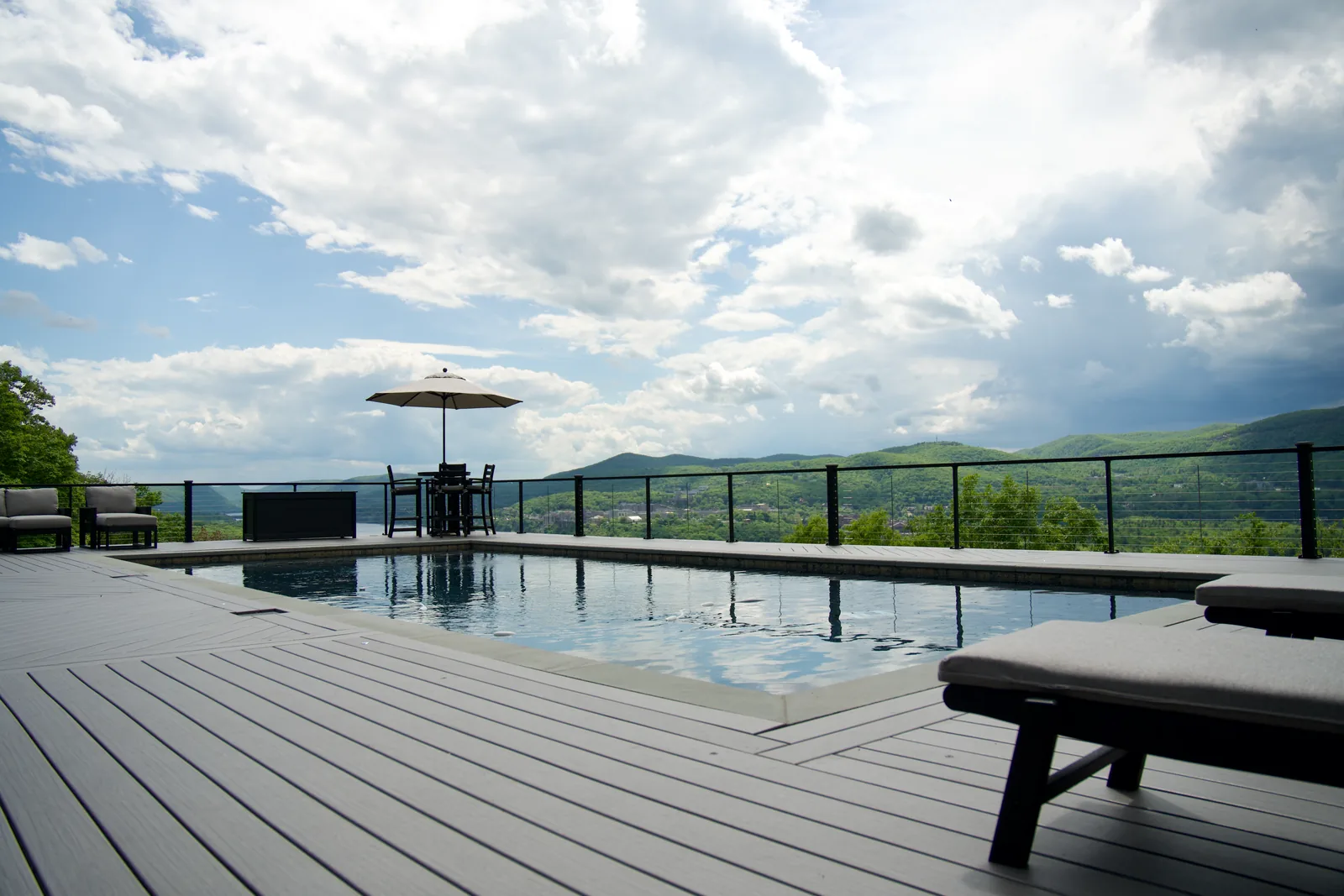 Infinity-edge pool with Signature cable railing and Hudson Highlands view in Garrison, NY