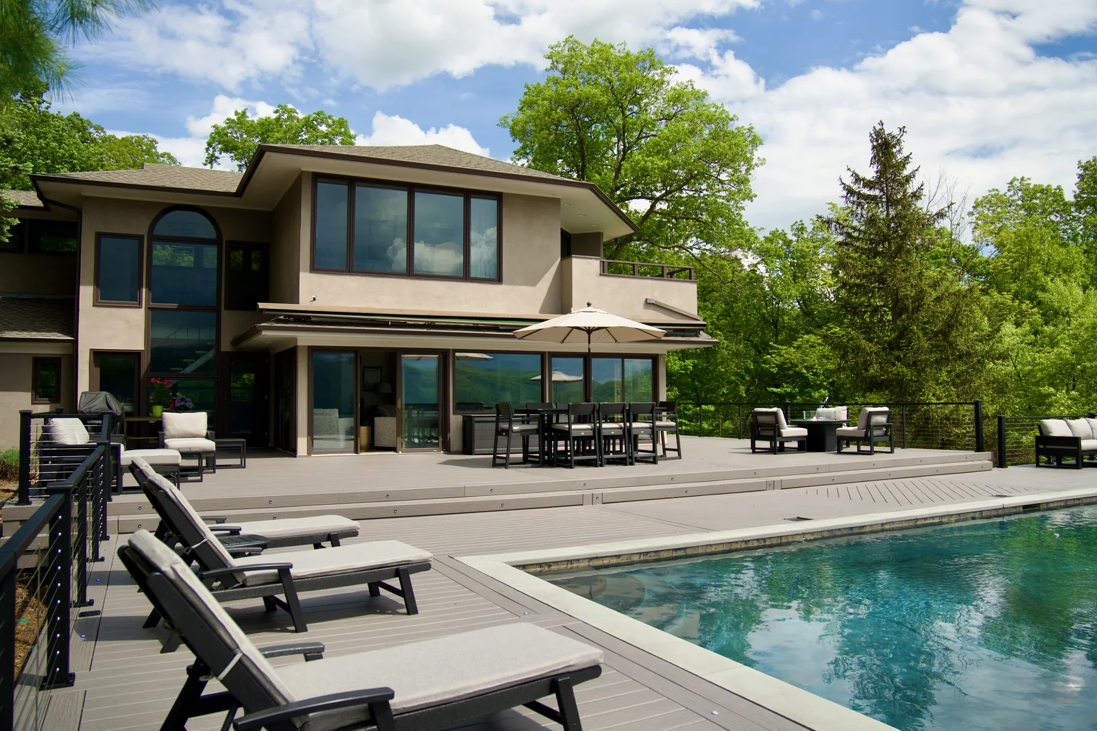 Poolside lounger row with Signature cable railing at a modern home in Garrison, NY