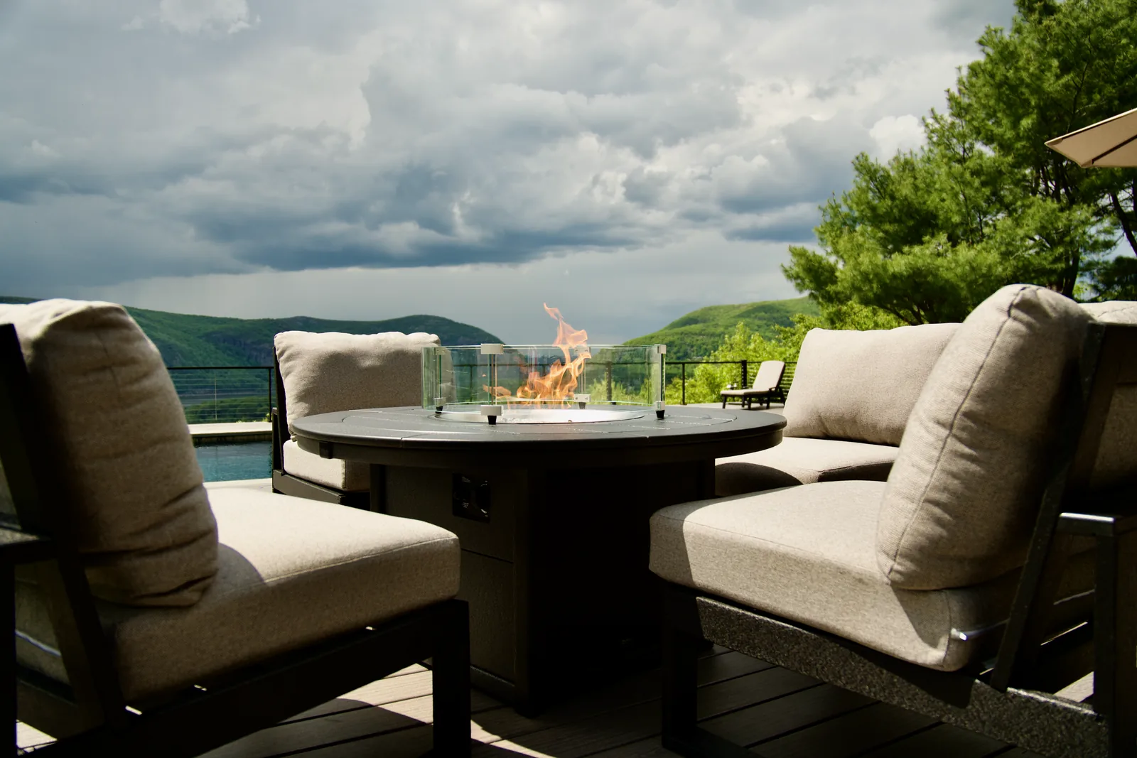 Lit fire table with flames against mountain panorama in Garrison, NY
