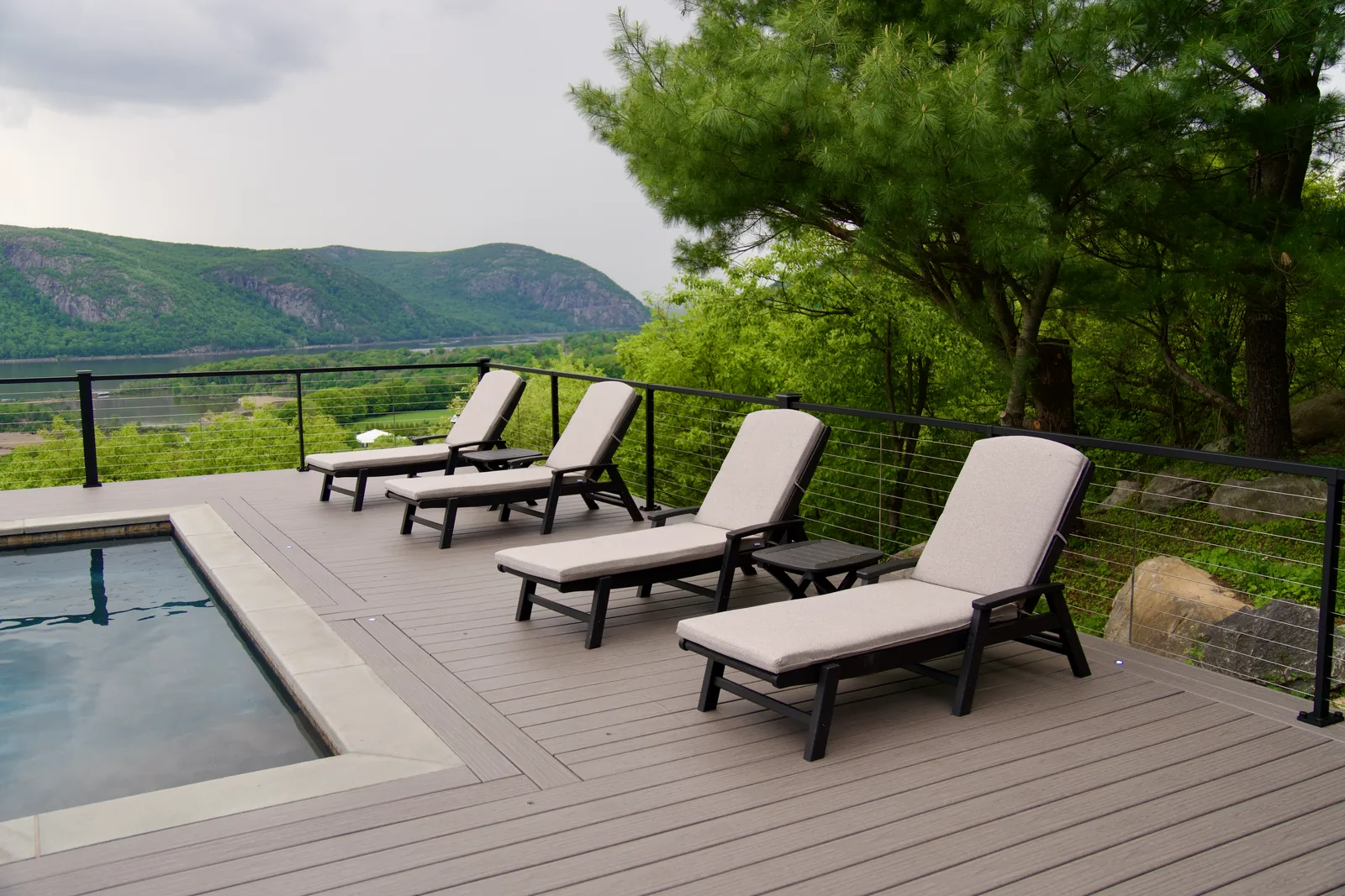 Lounger row with mountain view and Signature cable railing in Garrison, NY