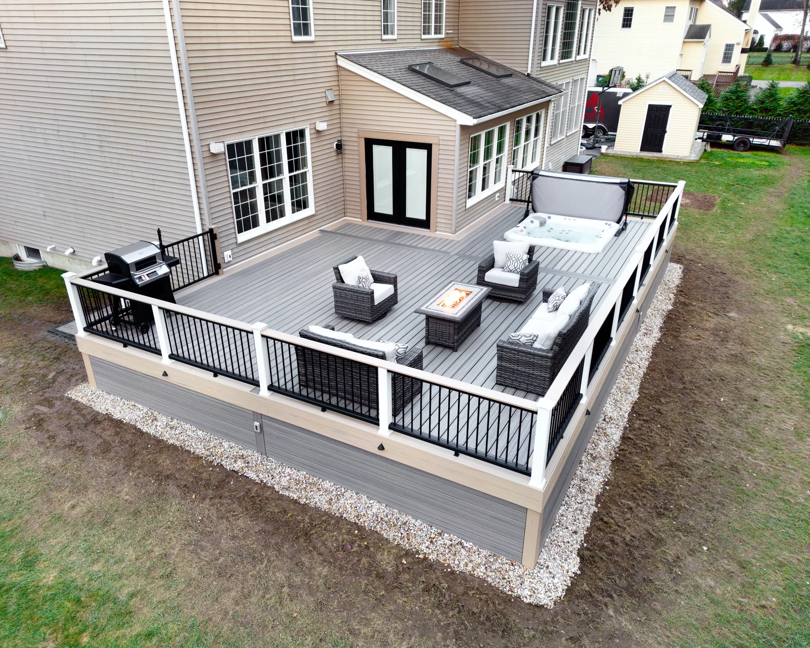 Drone aerial of finished deck with hot tub, fire table and outdoor kitchen in the Hudson Valley, NY