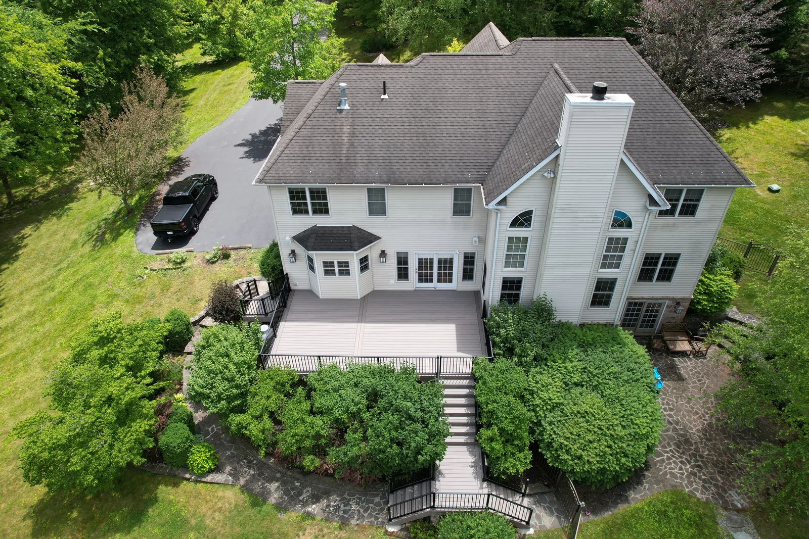 Aerial of an estate home with a multi-level deck and stone steps in the Hudson Valley, NY