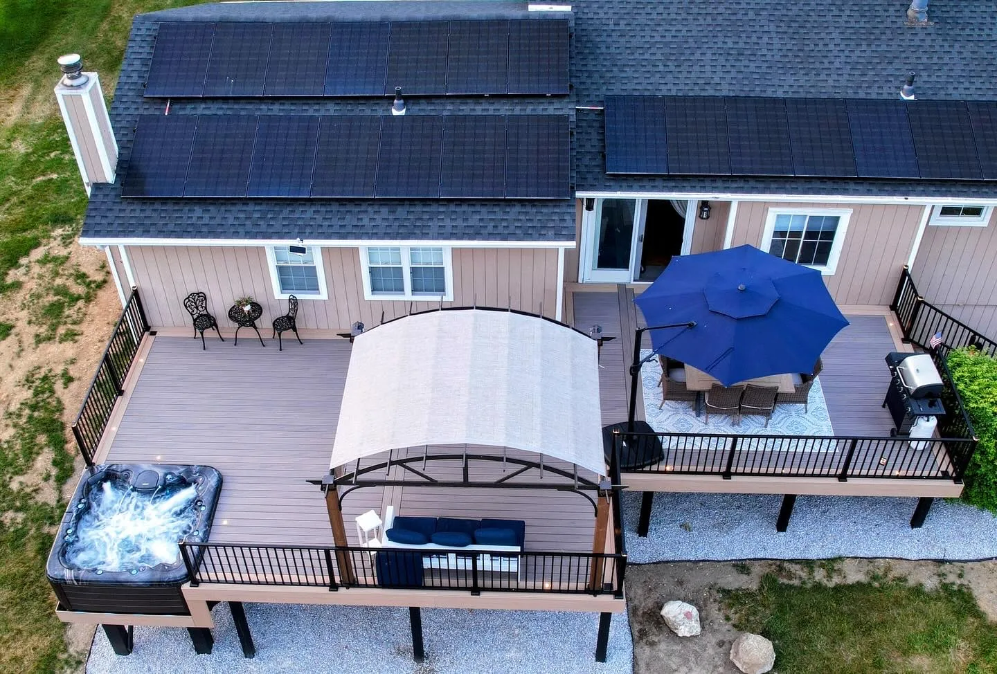 Aerial of a multi-level deck with hot tub, pergola, and dining area in the Hudson Valley, NY