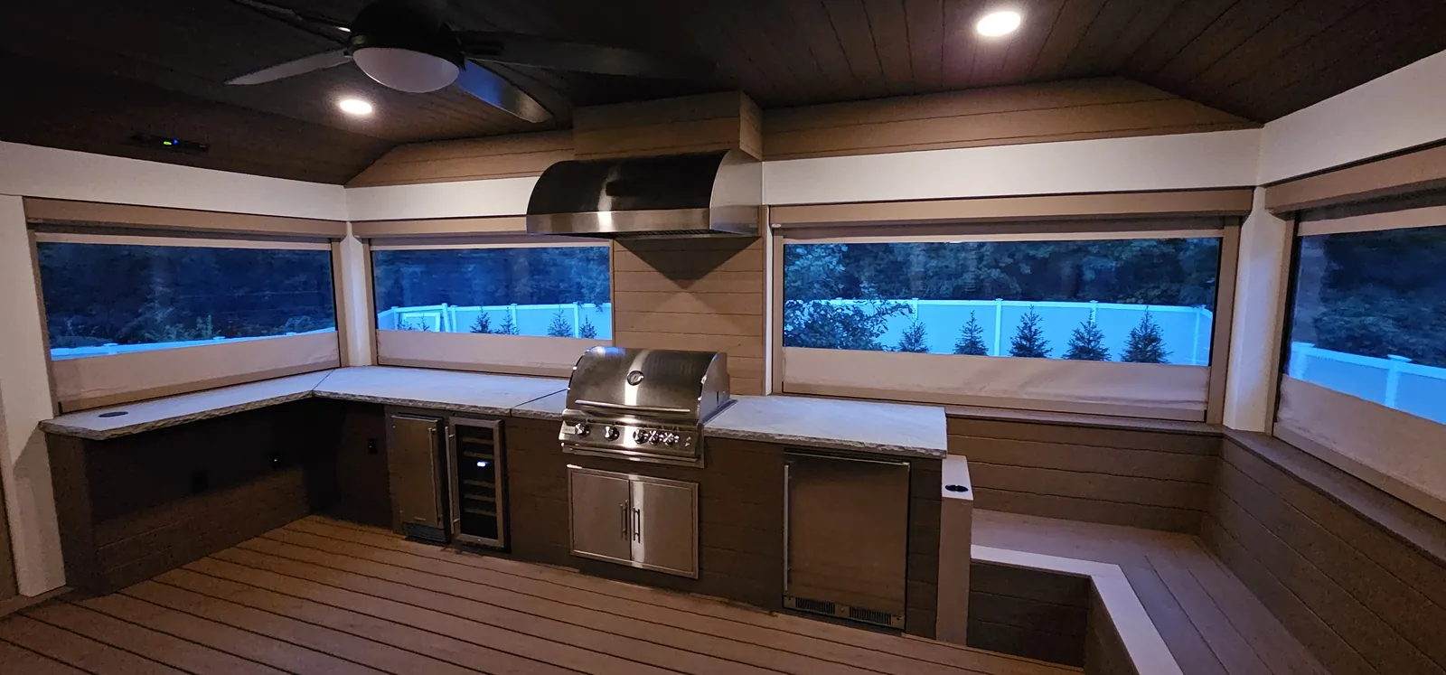 Covered outdoor kitchen at dusk with a built-in grill in the Hudson Valley, NY