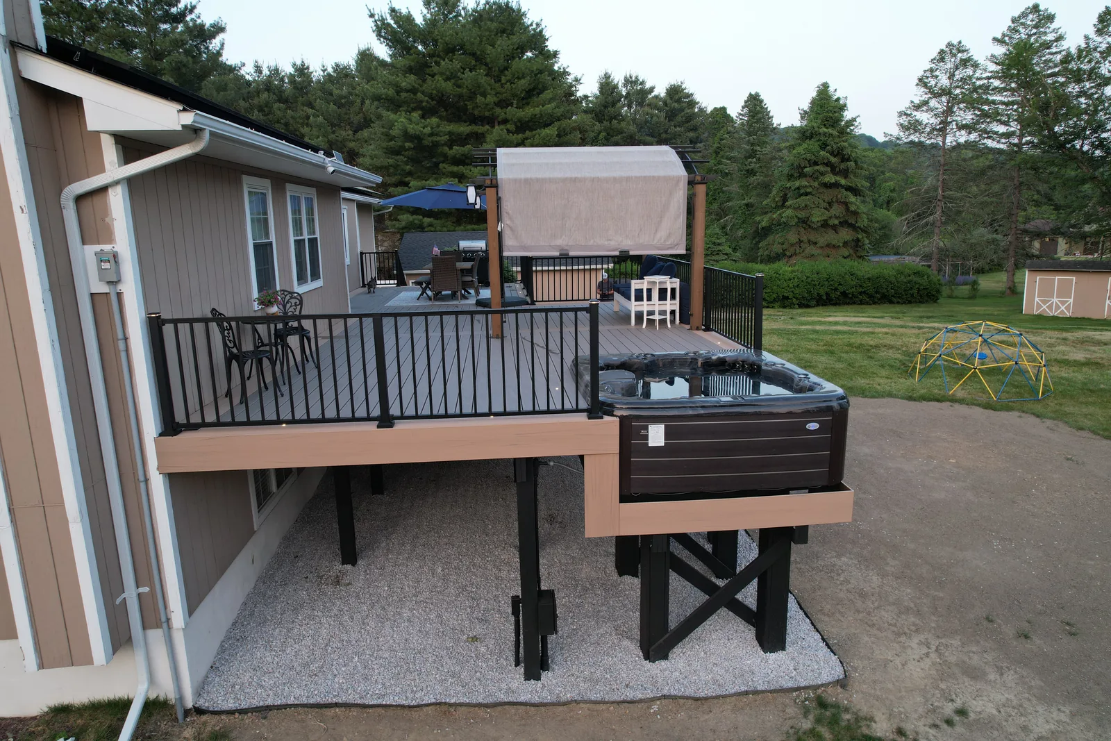 Elevated deck with pergola and built-in hot tub at dusk in the Hudson Valley, NY