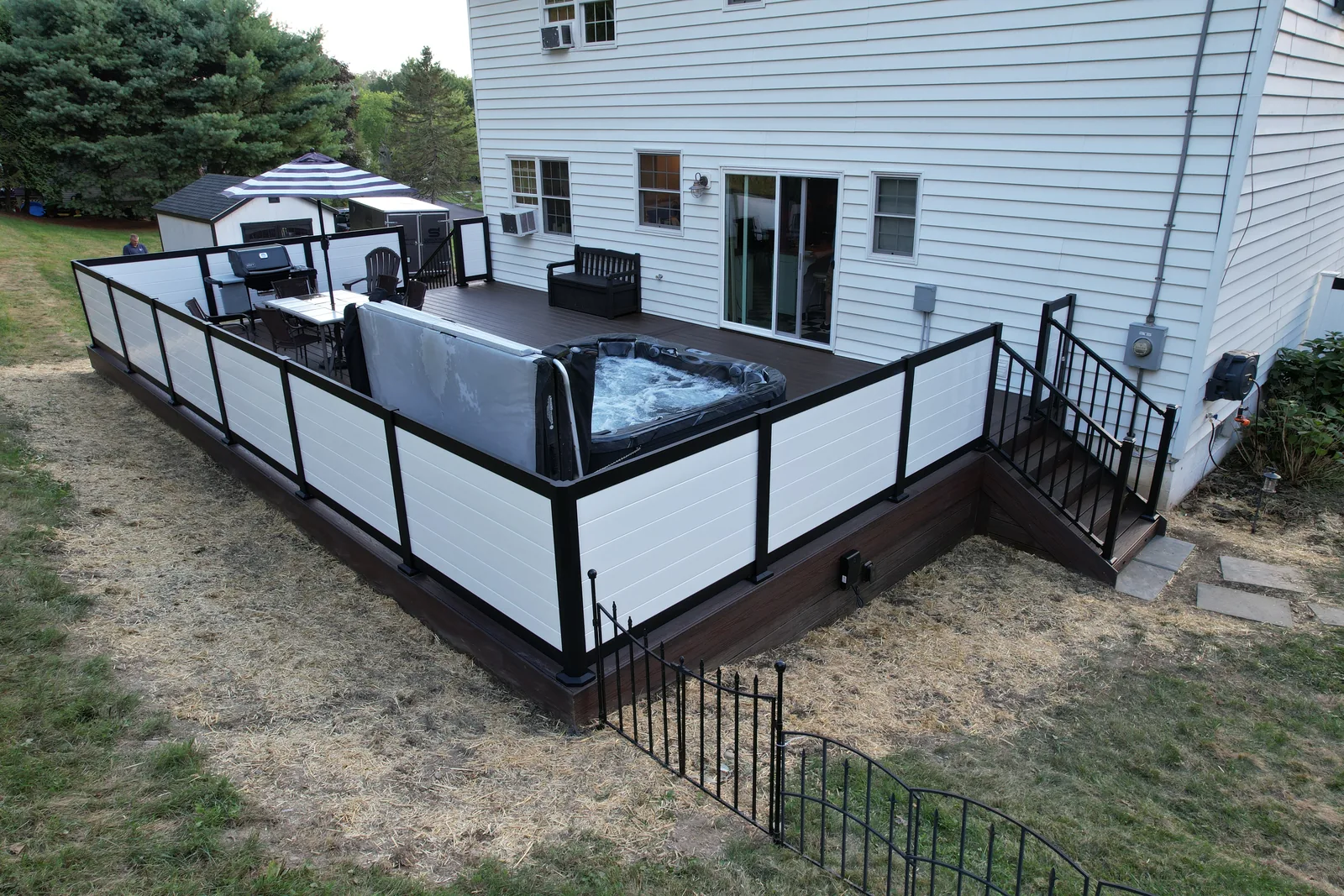 Aerial of a deck with a built-in hot tub and shaded dining area in the Hudson Valley, NY