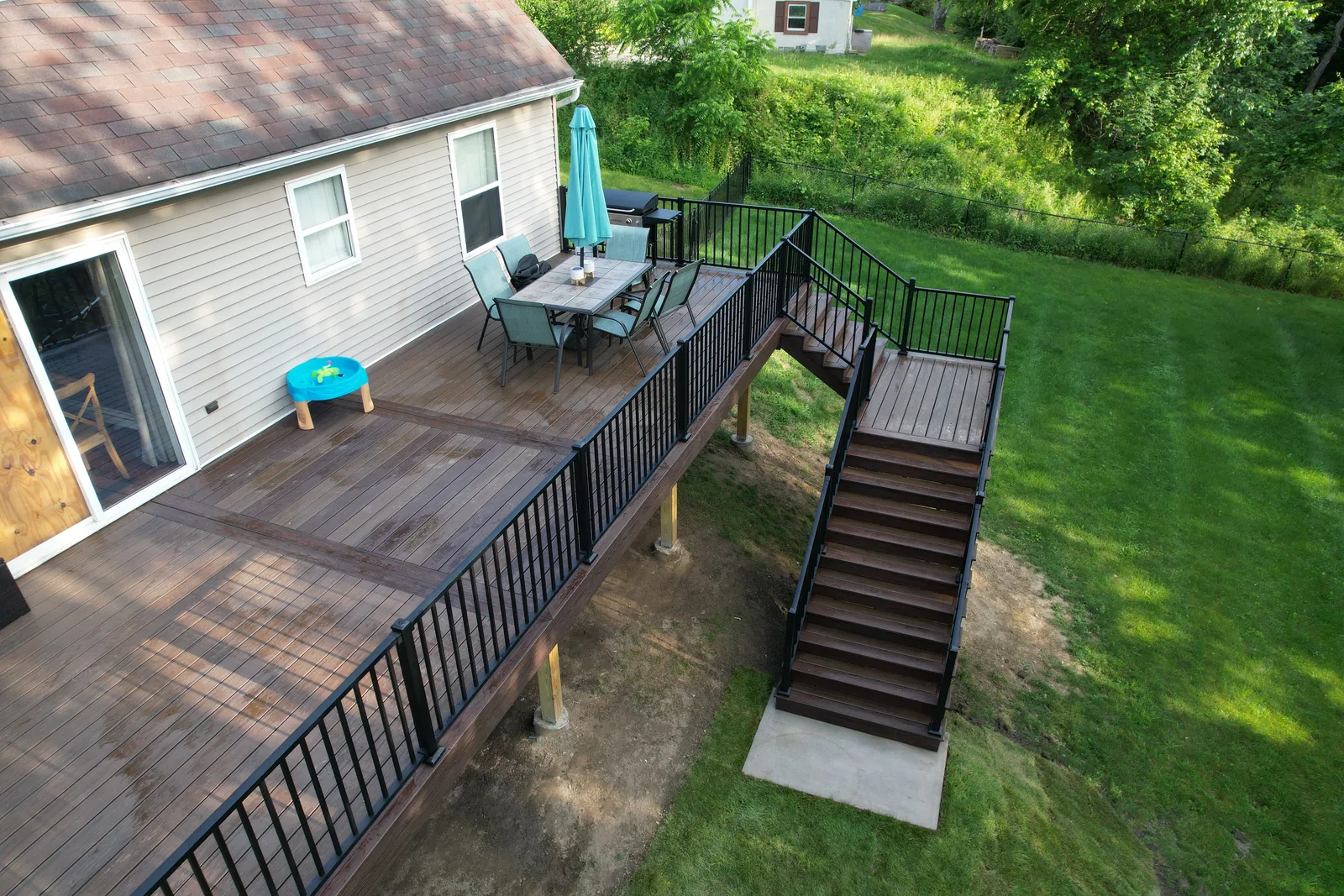 Aerial view of an elevated backyard composite deck with dining area and stairs in the Hudson Valley, NY