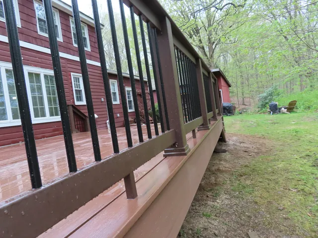 Composite deck with dark railing on a wooded lot, Putnam County
