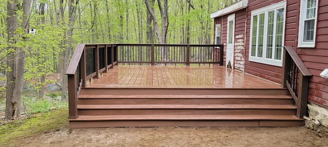 Composite deck with dark railing on a wooded lot, Putnam County