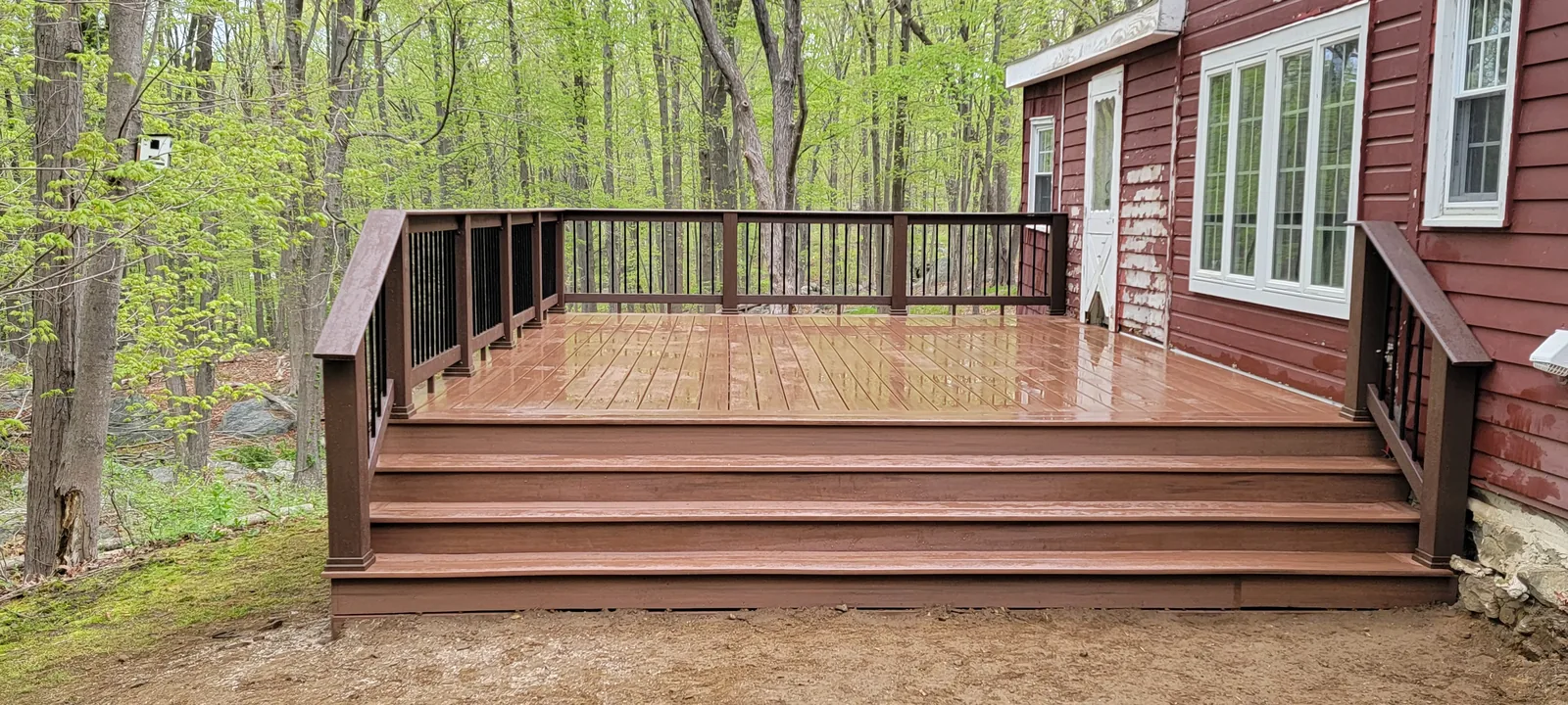 Backyard composite deck with broad steps among the trees in Putnam County, NY