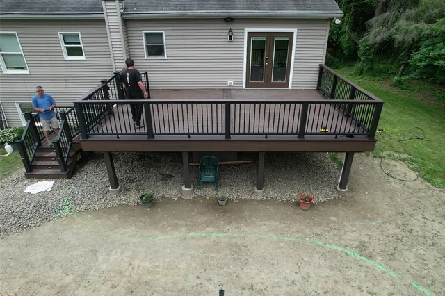 Deck with black railing above a backyard pool, Verbank, NY