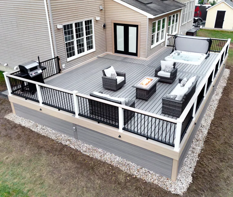 Gray deck with white-and-black railing and lounge furniture