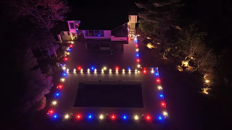 Aerial at night of a deck outlined in multicolor lights