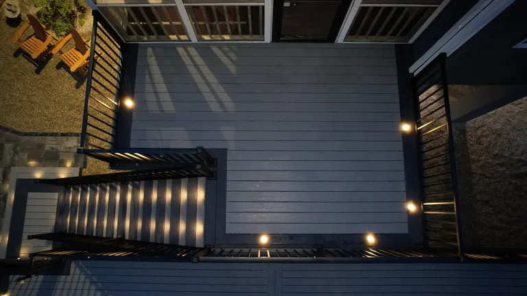 Aerial at night of a gray deck with lit stairs