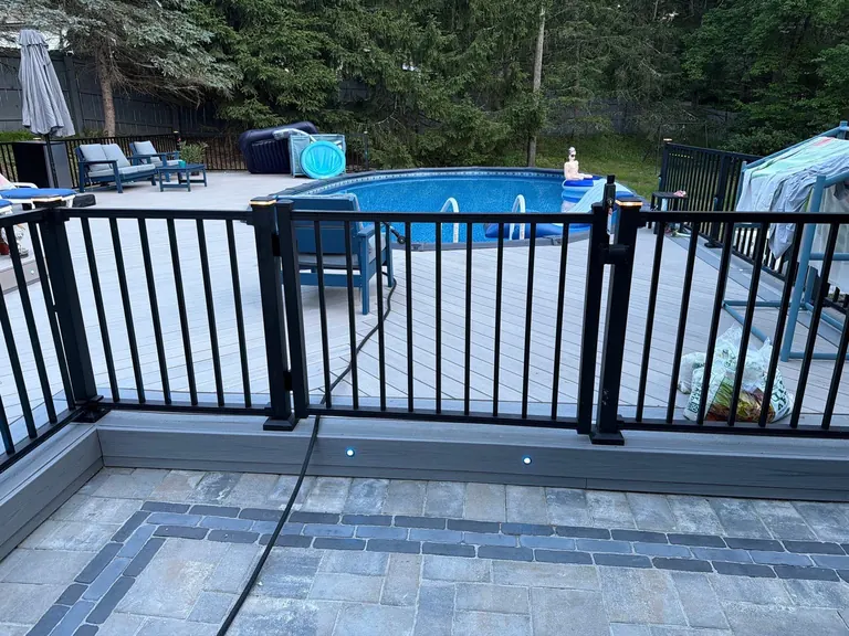 Wide view of black aluminum pool railing over a paver patio, Rhinebeck, NY