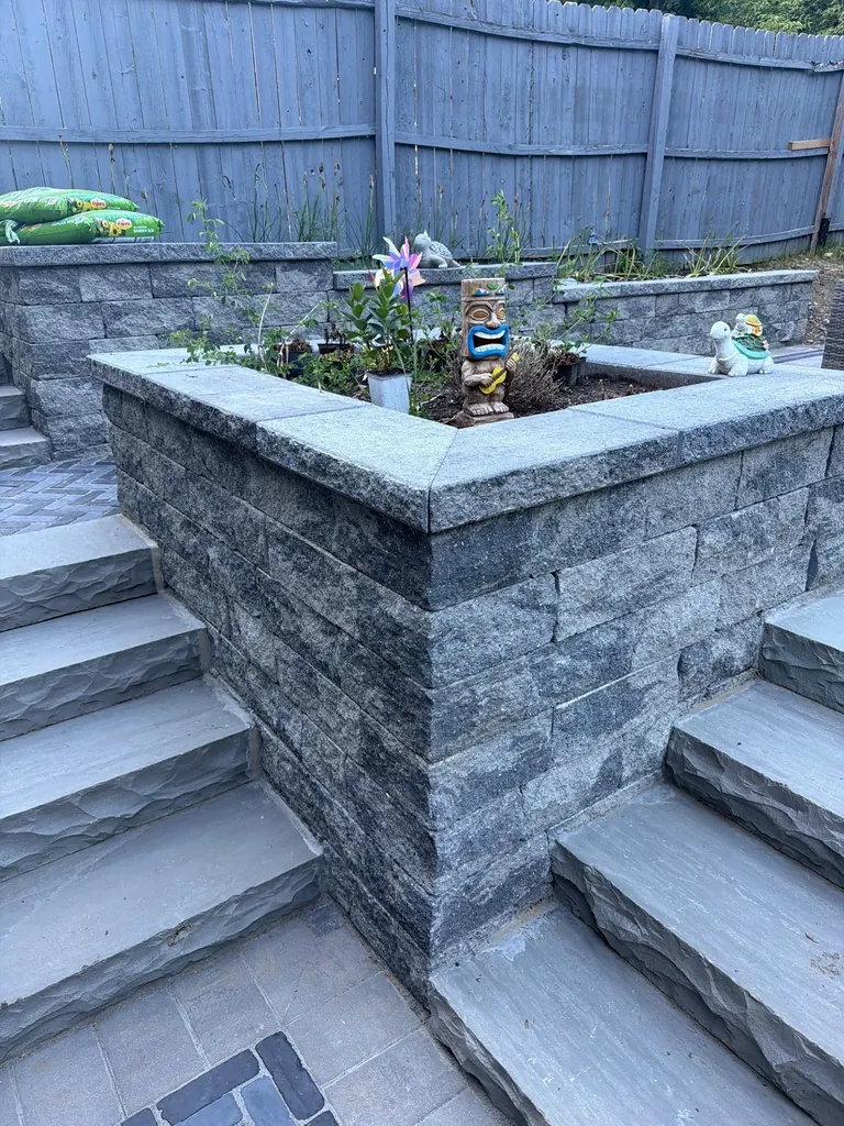 Detail of a stone planter box with small plants, Rhinebeck, NY
