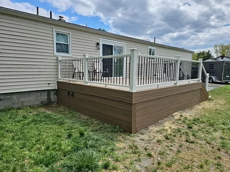 Wide rear view of the finished deck with outdoor furniture set up, white railing with black balusters, New Paltz, NY