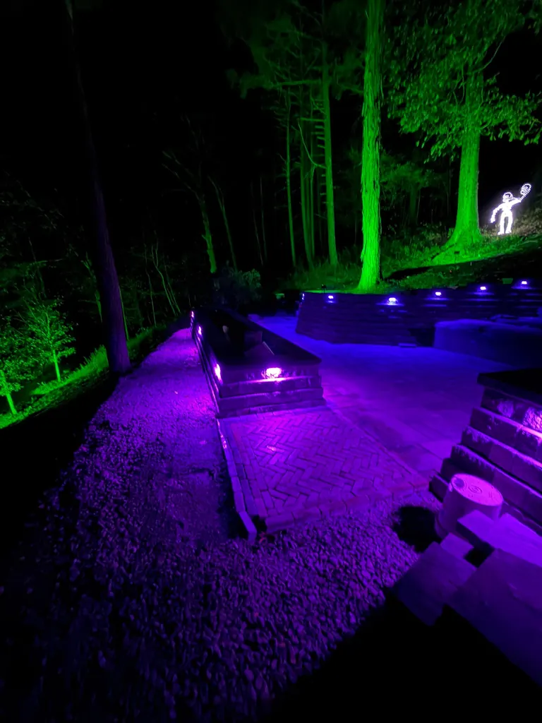 Terraced stone retaining wall lit in red, blue and green at night, Boiceville, NY