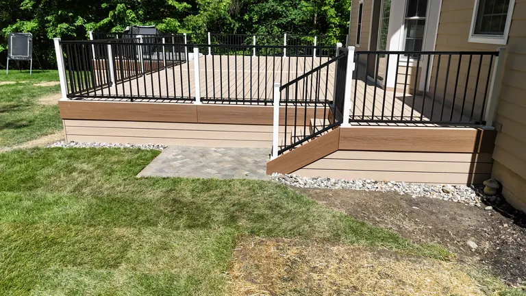 Two-tier deck with black railing, stairs, and paver landing against the house, Lagrangeville, NY