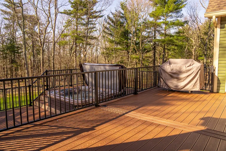 Wide deck shot with hot tub cover, house partially visible