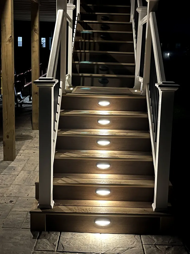 Night shot of same stair run from a step higher up, riser lights lit, neighbor house lit in background, Wappingers Falls, NY